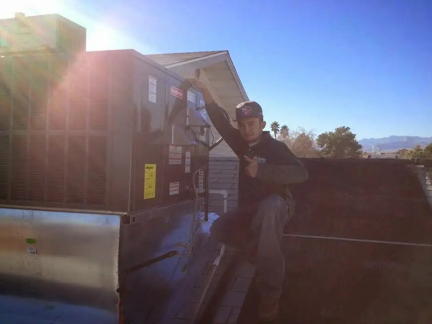 HVAC technician performing Air Duct Repair on a rooftop unit in Lake Alfred